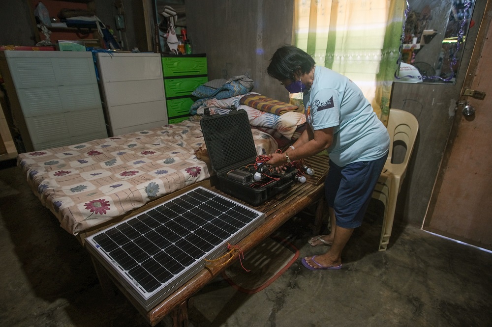 Lorna dela Pena takes out her TekPak solar-powered generator at her home in Marabut, Philippines October 17, 2021. u00e2u20acu201d Picture by Thomson Reuters Foundation/Geela Garcia