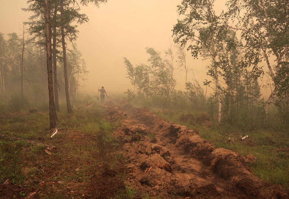 A man digs a control line during the work on extinguishing a forest fire near the village of Magaras in the region of Yakutia, Russia July 17, 2021. u00e2u20acu201d Reuters pic