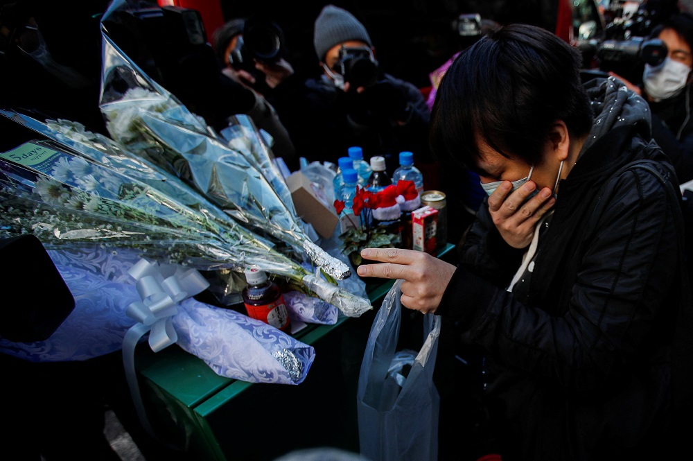 A person mourns for victims in front of a building where a fire broke out, in Osaka December 18, 2021. u00e2u20acu201d Reuters pic