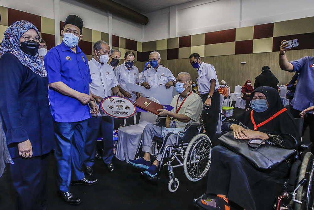 Tenaga Nasional Berhad Chairman, Datuk Seri Hasan Arifin (third left) together with Federal Territories Minister Datuk Seri Shahidan Kassim (second left) handing over keys to recipients. u00e2u20acu201d Picture by Hari Anggara