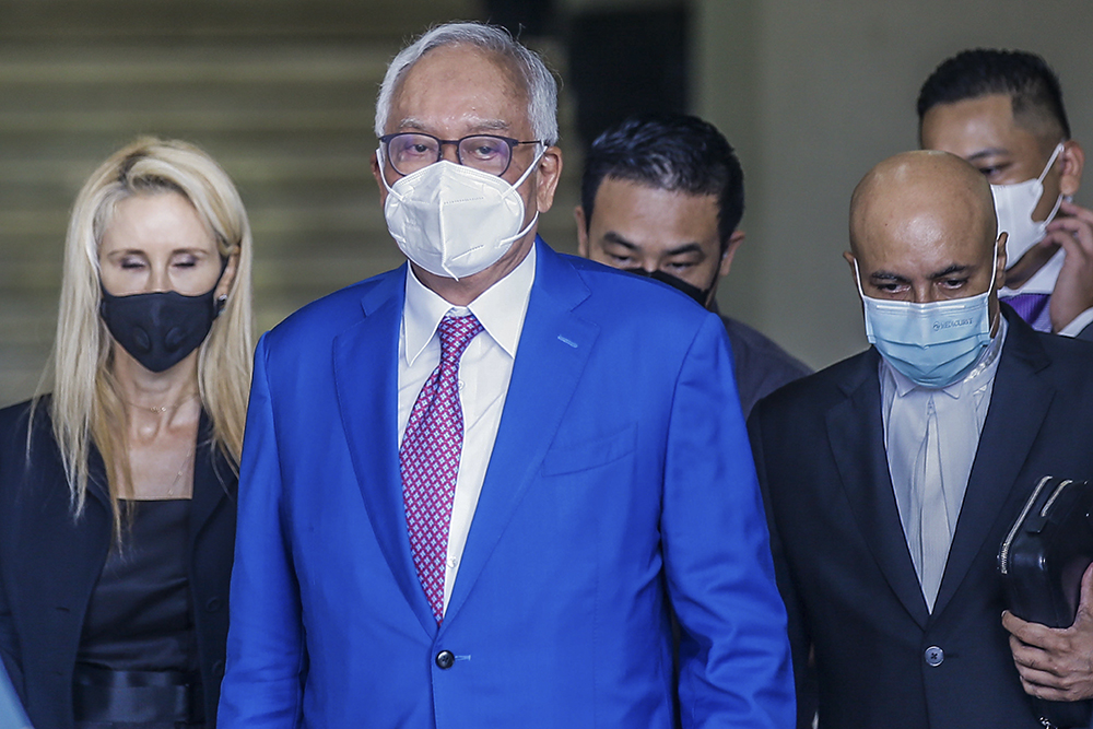 Najib is seen leaving the court building with his lawyers, after his 1MDB trial did not go on. December 13, 2021. — Picture by Hari Anggara