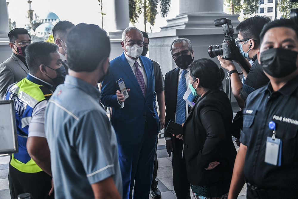 Datuk Seri Najib Razak shows his MySejahtera status to a court personnel, while his lawyer Tan Sri Muhammad Shafee Abdullah's MySejahtera status is also inspected at the Kuala Lumpur High Court. December 13, 2021. u00e2u20acu201d Picture by Hari Anggara