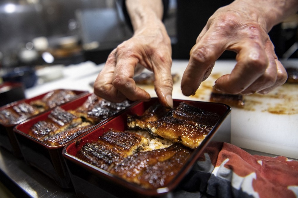In this photo taken on April 16, 2021, Japanese chef Tsuyoshi Hachisuka prepares grilled eel before serving them to customers at his restaurant in Hamamatsu, Shizuoka prefecture. — AFP pic