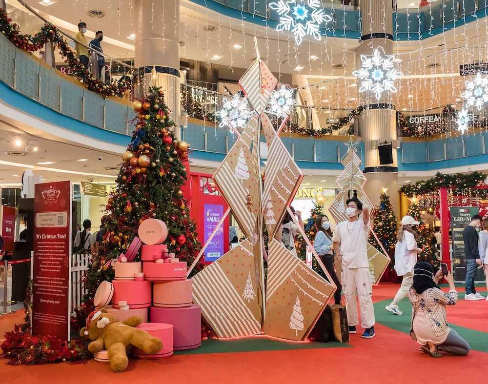 Visitors taking pictures with the backdrop of a Christmas tree and gifts stacked up for the festive season. u00e2u20acu201d Picture by Devan Manuel.nn