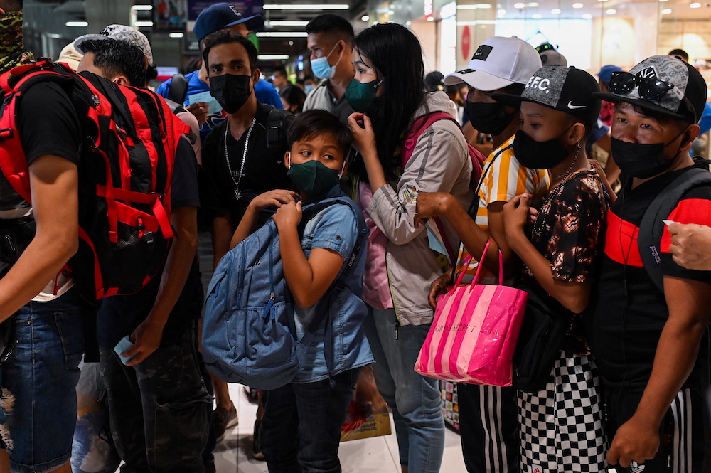 People wearing face masks wait to ride a bus going to provinces, a day before the New Year's Eve, at a bus terminal in Paranaque City, Metro Manila, Philippines, December 30, 2021. u00e2u20acu201d Reuters pic 