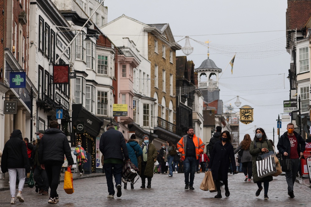 Shoppers, some wearing face coverings, pass High Street stores on Christmas Eve in Guildford, south of London December 24, 2021. u00e2u20acu201d AFP pic