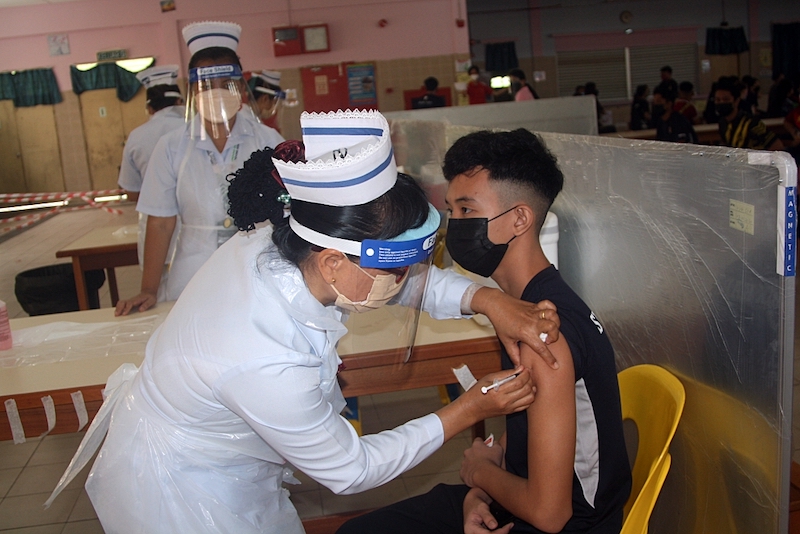 A nurse administers the second dose of the Covid-19 vaccine on a student from SMK Kapit No 2. — Borneo Post pic
