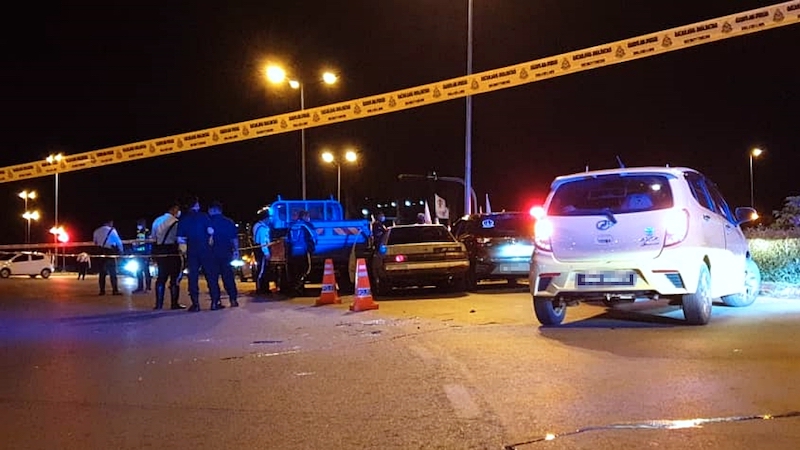 Police at the site not far from the traffic light intersection at Jalan Simpang Tiga in Kuching, where a man was shot dead on late evening of Dec 15. — Borneo Post pic