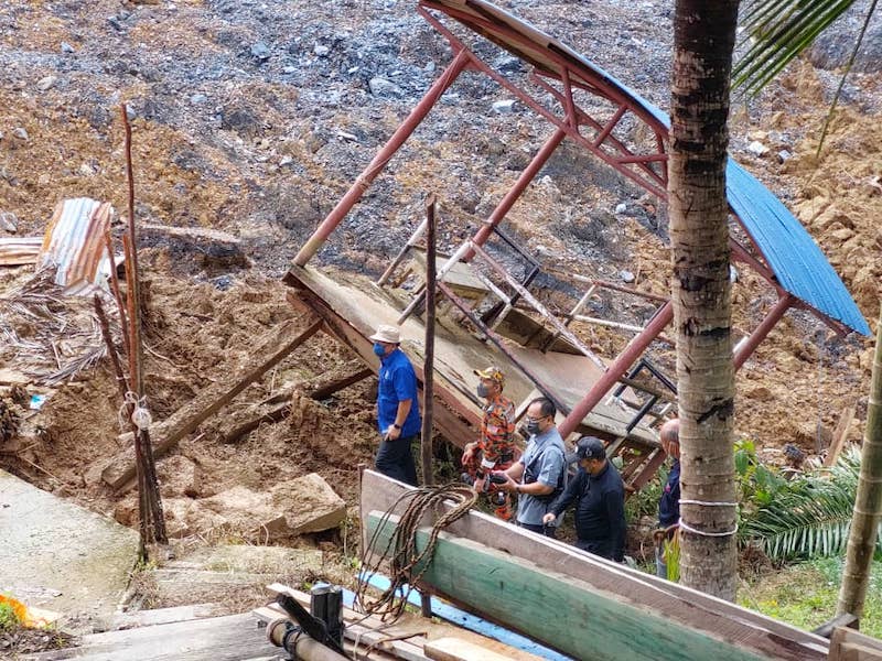 (from left) Ugak, accompanied by Kapit Fire and Rescue officer Irwanddy Tugor, Bukit Mabong District officer Robert Liman and others, inspects the landslide-hit area in front of Rumah Jantai. u00e2u20acu201d Borneo Post pic