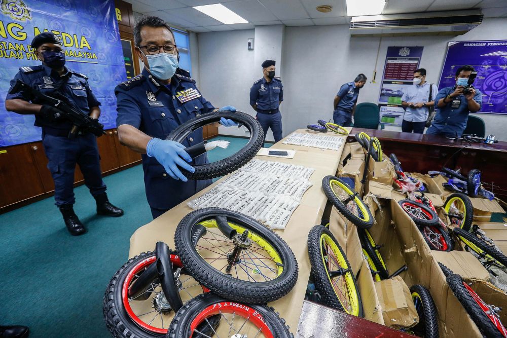 Penang Customs director Abdul Halim Ramli shows how a bicycle tyre is used to conceal drugs during a press conference at the Penang Royal Malaysian Customs Complex in Perai December 30, 2021. u00e2u20acu201d Picture by Sayuti Zainudin