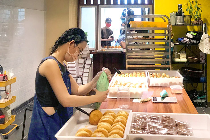 Busy at work while customers queue up outside for their orders.