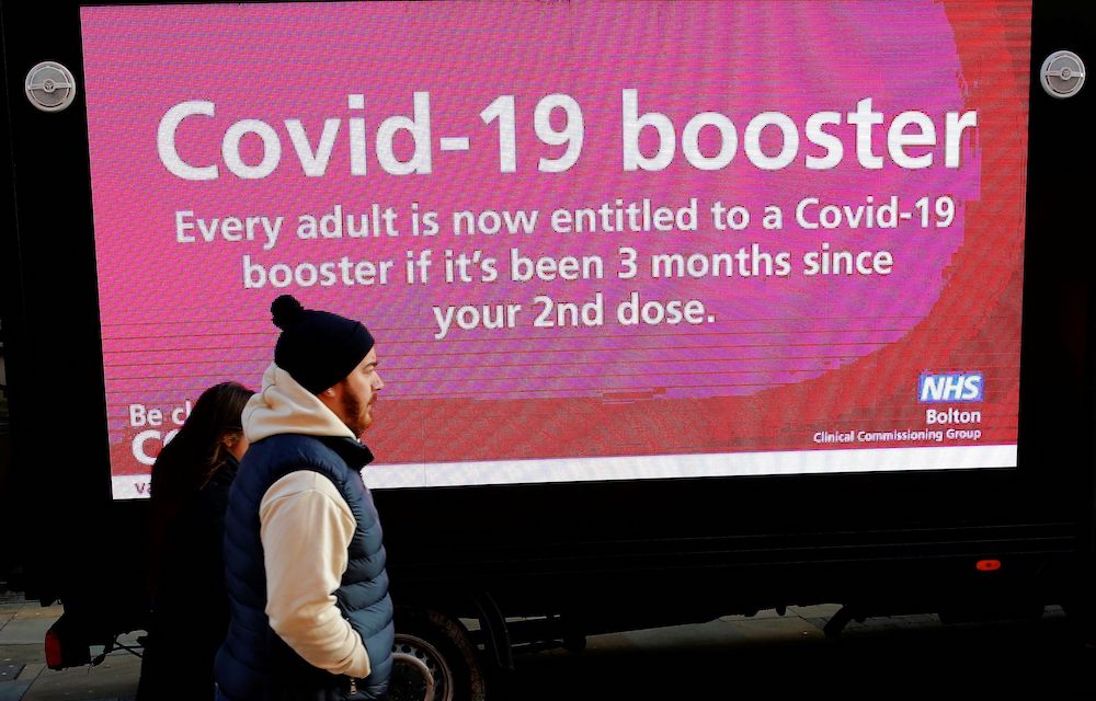 People walk past a mobile advertising screen encouraging people to get a Covid-19 booster vaccine in Bolton, Britain, December 18, 2021. u00e2u20acu201d Reuters picnn