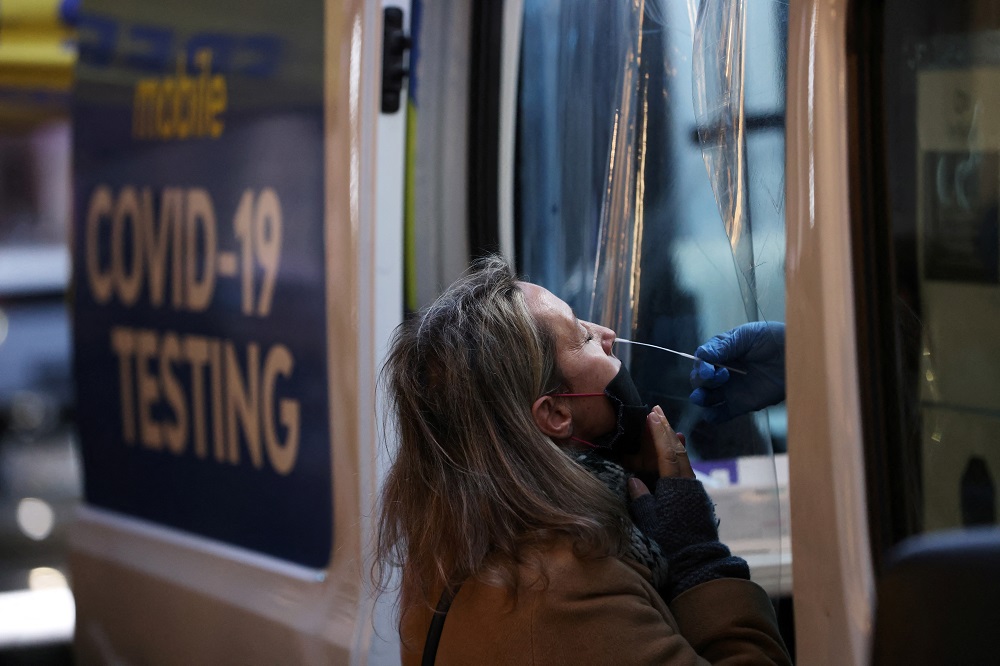A person takes a Covid-19 test on Broadway as the Omicron coronavirus variant continues to spread in Manhattan, New York December 27, 2021. u00e2u20acu2022 Reuters pic