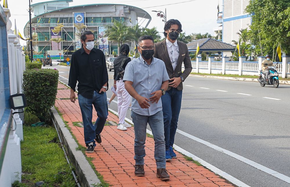 Director Mohd Latif Zami (centre), assistant director Saiful Zaidrin Ismail (left) and actor Muhamad Niezam Mohd Zaidi arrive at the Kuala Kangsar Magistrateu00e2u20acu2122s Court December 1, 2021. u00e2u20acu201d Picture by Farhan Najibnn