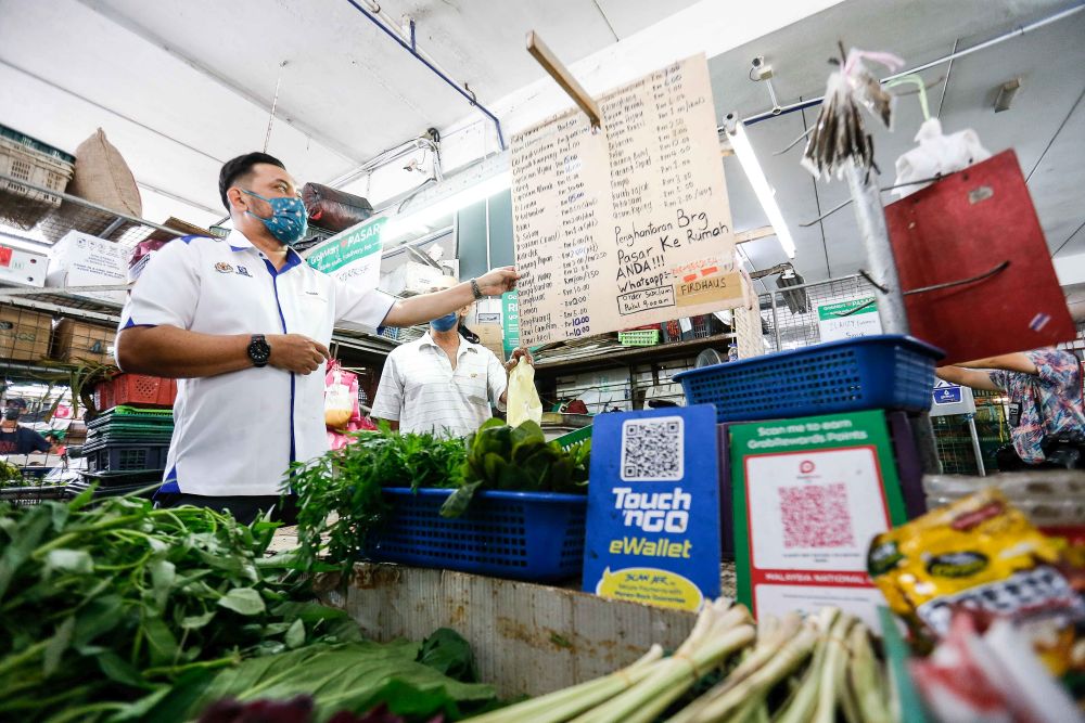Director of Penang Ministry of Domestic Trade and Consumers Affairs Mohd Ridzuan Ab Ghapar checks on vegetables prices at the Bayan Baru Wet Market on December 1, 2021. u00e2u20acu201d Picture by Sayuti Zainudinnnn