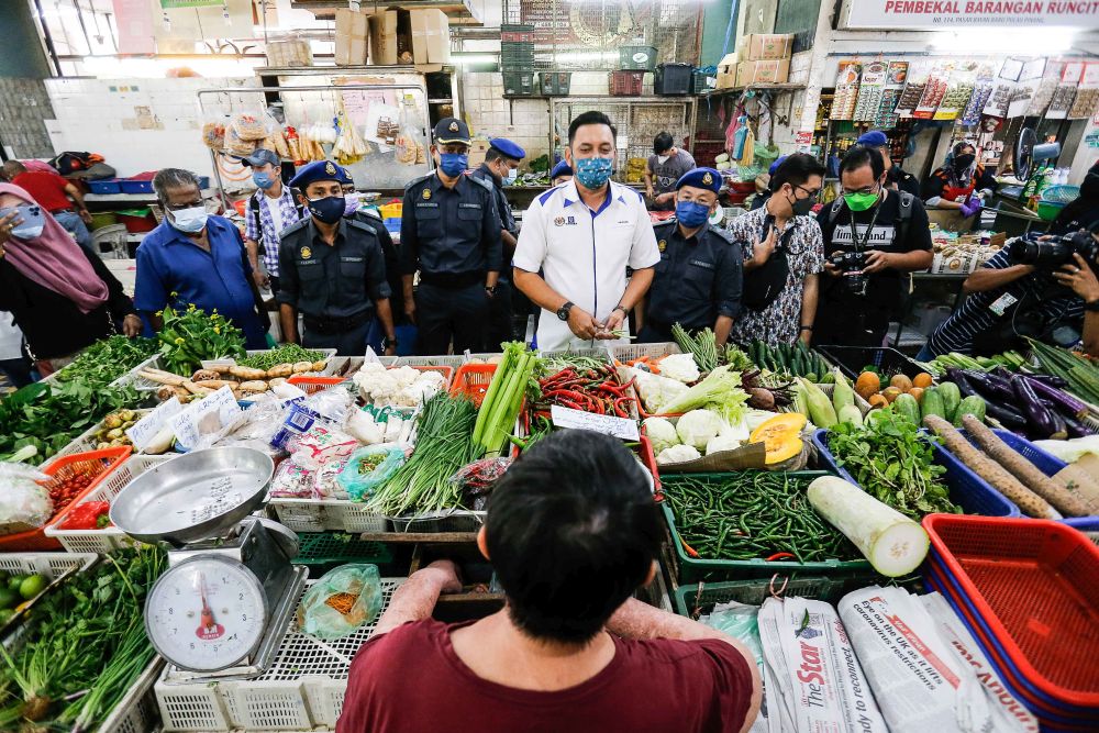Director of Penang Ministry of Domestic Trade and Consumers Affairs Mohd Ridzuan Ab Ghapar speaks to a trader at the Bayan Baru Wet Market on December 1, 2021. — Picture by Sayuti Zainudin