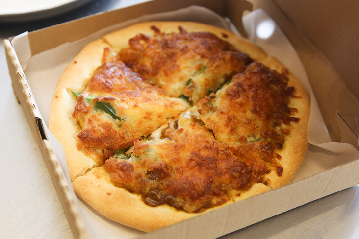 The hand tossed pizza uses bread flour and is served with Japanese flavours like this curry version.