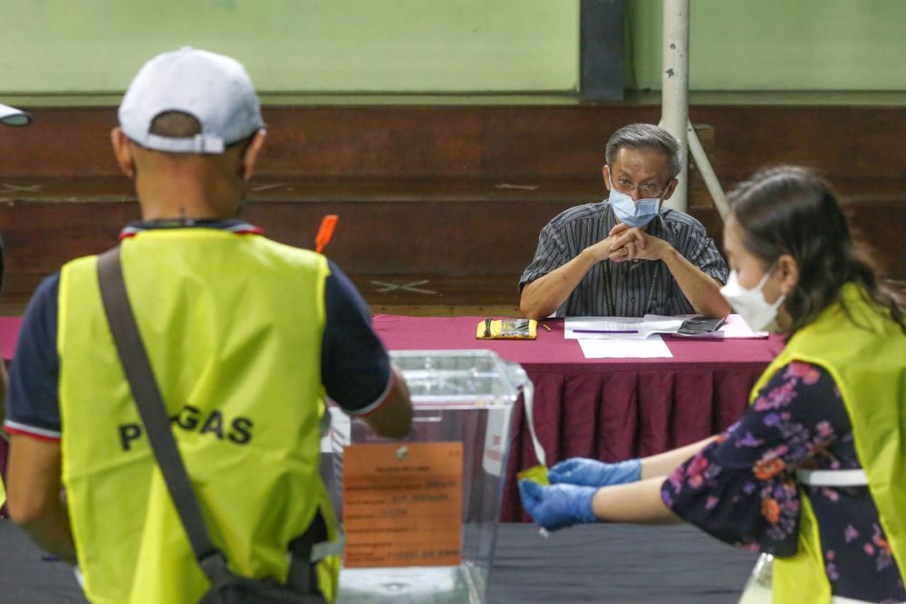 Parti Bumi Kenyalang candidate Raymond Thong Ee Yu serves as polling station agent during early voting for the Sarawak state election in Kuching December 14, 2021. u00e2u20acu201d Picture by Yusof Mat Isa