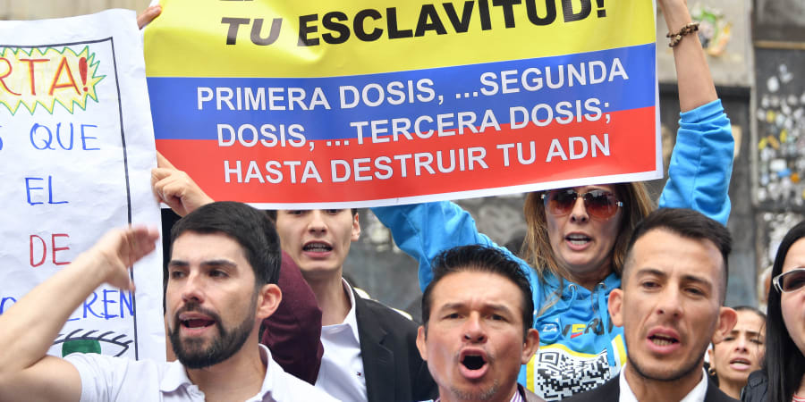 A woman holds a poster that reads u00e2u20acu02dcThe vaccine will be your slavery. First dose, second dose, third dose, until your DNA is destroyed.u00e2u20acu2122 u00e2u20acu201d ETX Studio picnn