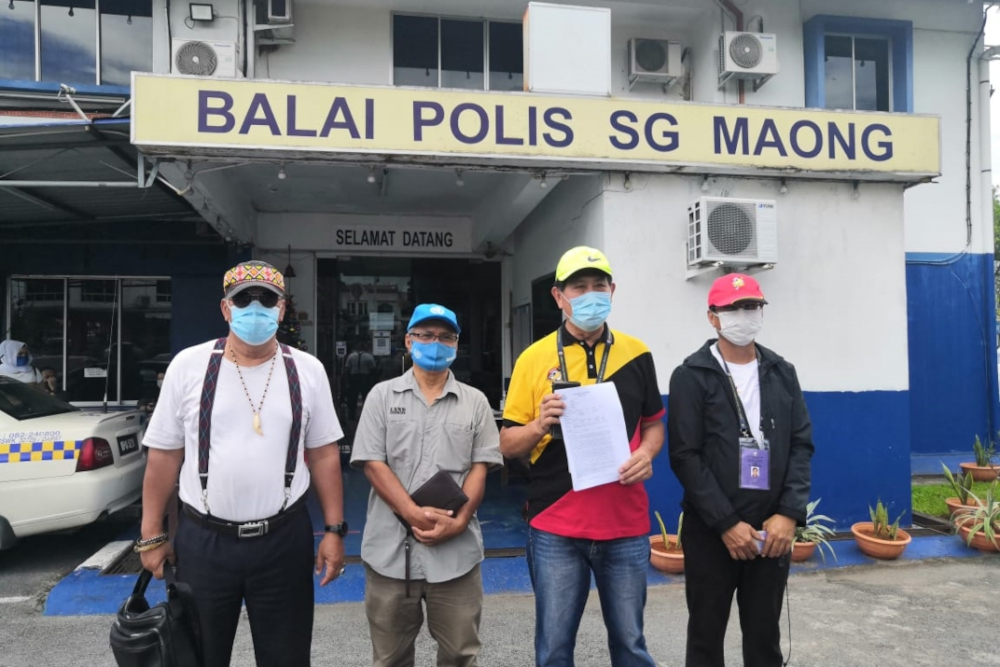 PBK president Voon Lee Shan (second right) shows the police report together with his supporters in front of the Sungai Maong police station today. u00e2u20acu201d Borneo Post Online pic 