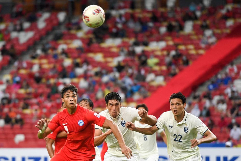 Thailand's players (in white) run for the ball during the AFF Suzuki Cup clash with Singapore at the National Stadium in Singapore December 18, 2021. u00e2u20acu2022 AFP pic