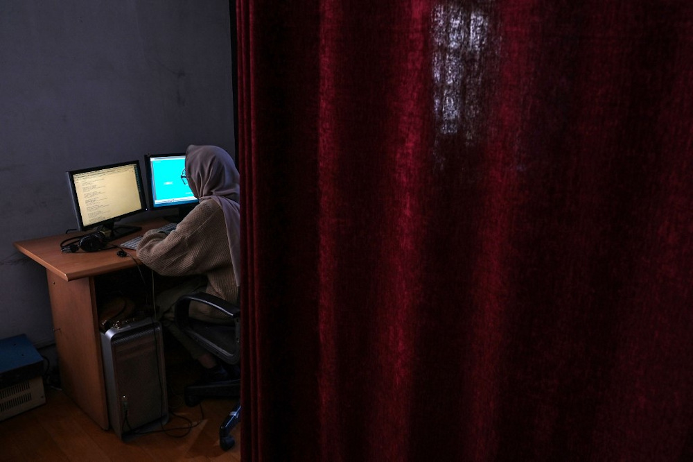 This picture taken on November 28, 2021 shows a woman working behind a curtain which is placed to separate women from men who work at Radio Begum in Kabul. u00e2u20acu201d AFP pic