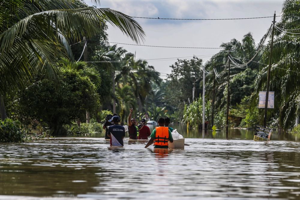 Flood victims evacuate their homes on boats and on foot in Kampung Labohan Dagang, Banting December 22, 2021. u00e2u20acu201d Picture by Hari Anggara