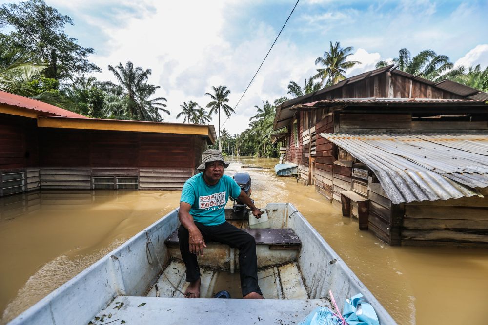 Flood victims evacuate their homes on boats and on foot in Kampung Labohan Dagang, Banting December 22, 2021. u00e2u20acu201d Picture by Hari Anggara