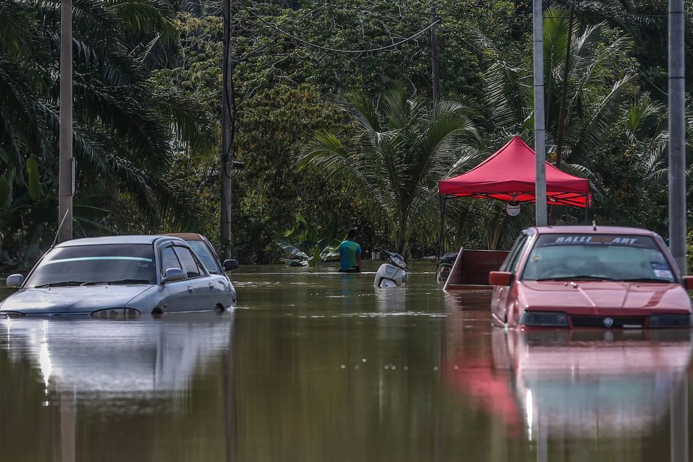 A man is pictured wading through floodwaters in Kampung Labohan Dagang, Banting December 22, 2021. u00e2u20acu201d Picture by Hari Anggara