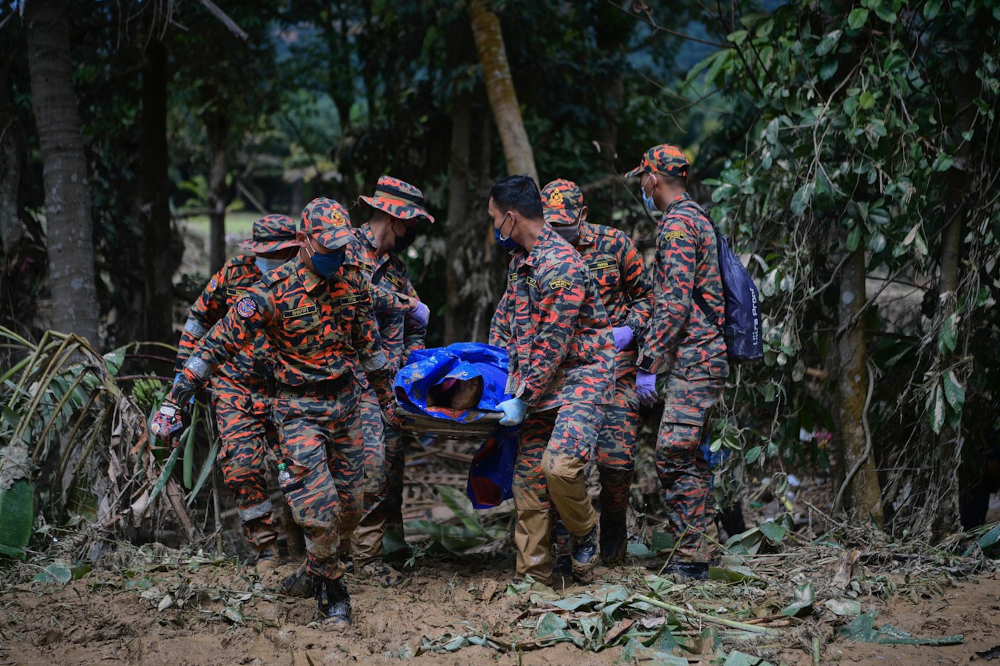 Malaysian Fire and Rescue Department (JBPM) personnel bring out one of three bodies of mud flood victims in Sungai Telemong in Pahang, December 20, 2021. u00e2u20acu201d Bernama pic 