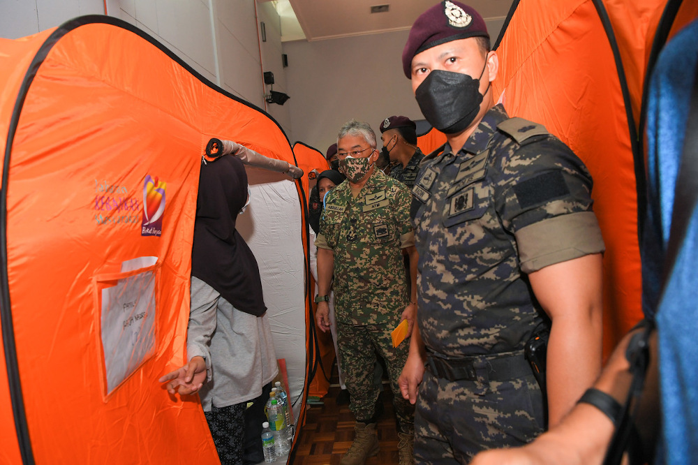 Yang di-Pertuan Agong Al-Sultan Abdullah Ri'ayatuddin Al-Mustafa Billah Shah meets a flood victim during a visit to the flood relief centre at the Centre for Instructor and Advanced Skill Training in Shah Alam December 25, 2021. u00e2u20acu201d Picture via Twitter