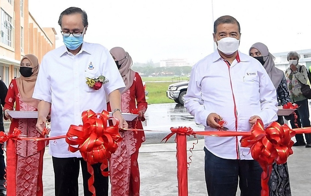 Datuk Seri Masidi Manjun (left) cutting the ribbon to mark the opening of the Lahad Datu Bus Terminal on Saturday. u00e2u20acu201d Bernama pic