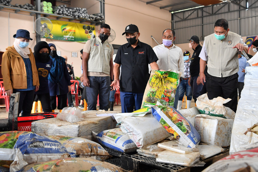 Agriculture and Food Industries Minister Datuk Seri Ronald Kiandee (centre) looks at a Fama Operations Centre warehouse affected by floods in Hulu Langat December 21, 2021. u00e2u20acu201d Bernama pic
