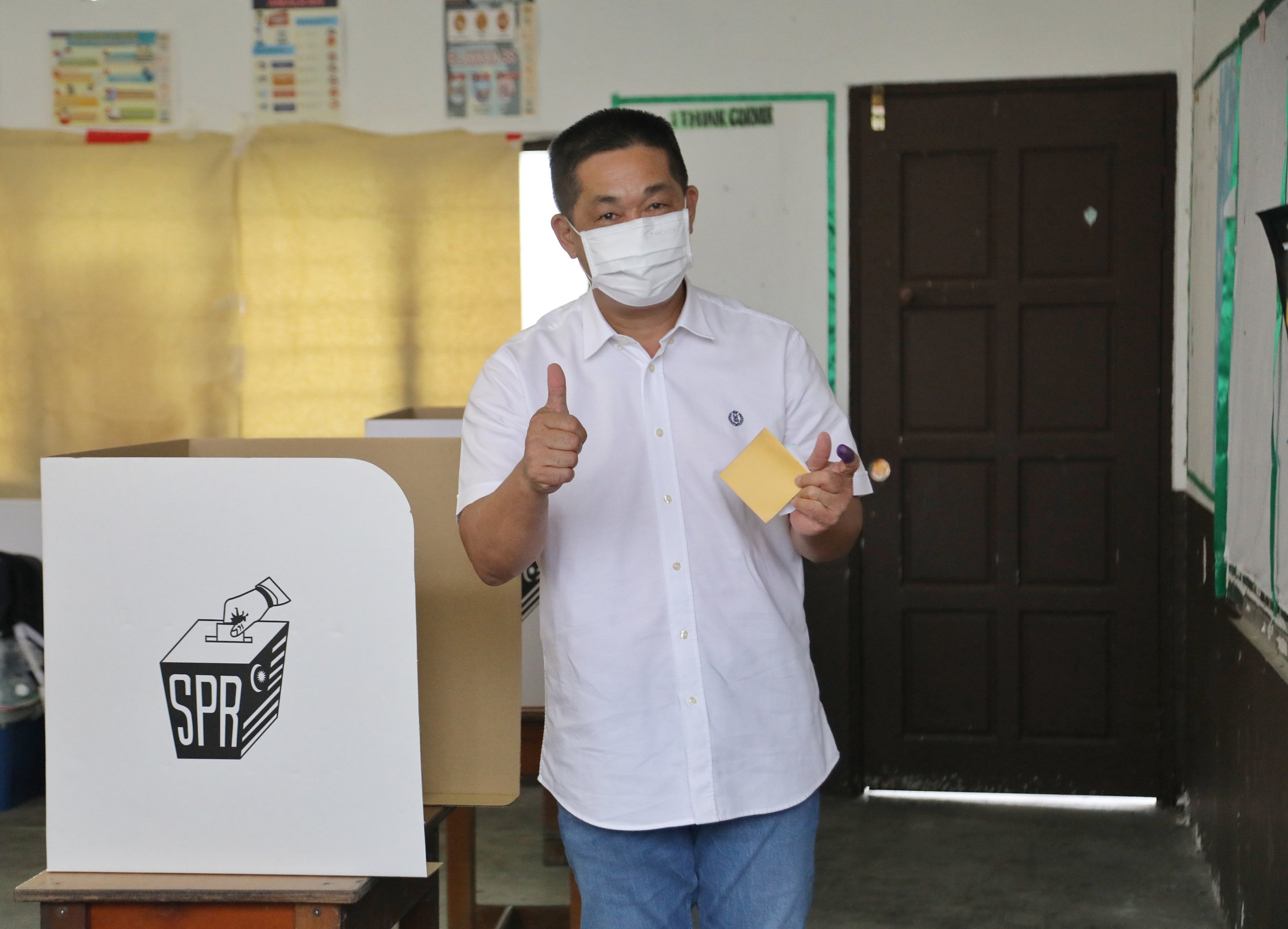 See gesturing to the camera while holding his ballot paper at SK Garland this morning. u00e2u20acu2022 Picture by Chimon Upon/Borneo Post