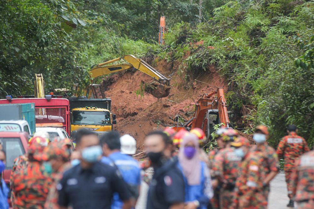 Excavators are pictured clearing soil and debris following a landslide along Jalan Simpang Pulai December 3, 2021. u00e2u20acu201d Picture by Farhan Najib