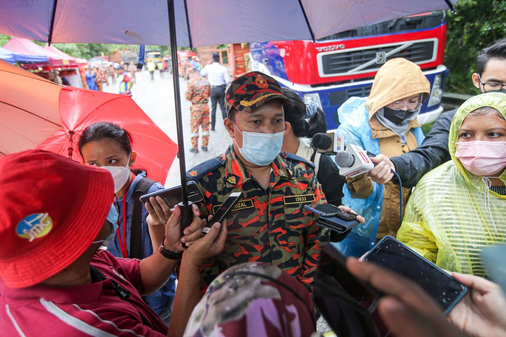 Perak Fire and Rescue Department’s assistant director Muhamad Shahrizal Aris speaks to reporters near the site of the landslide along Jalan Simpang Pulai December 3, 2021. — Picture by Farhan Najib