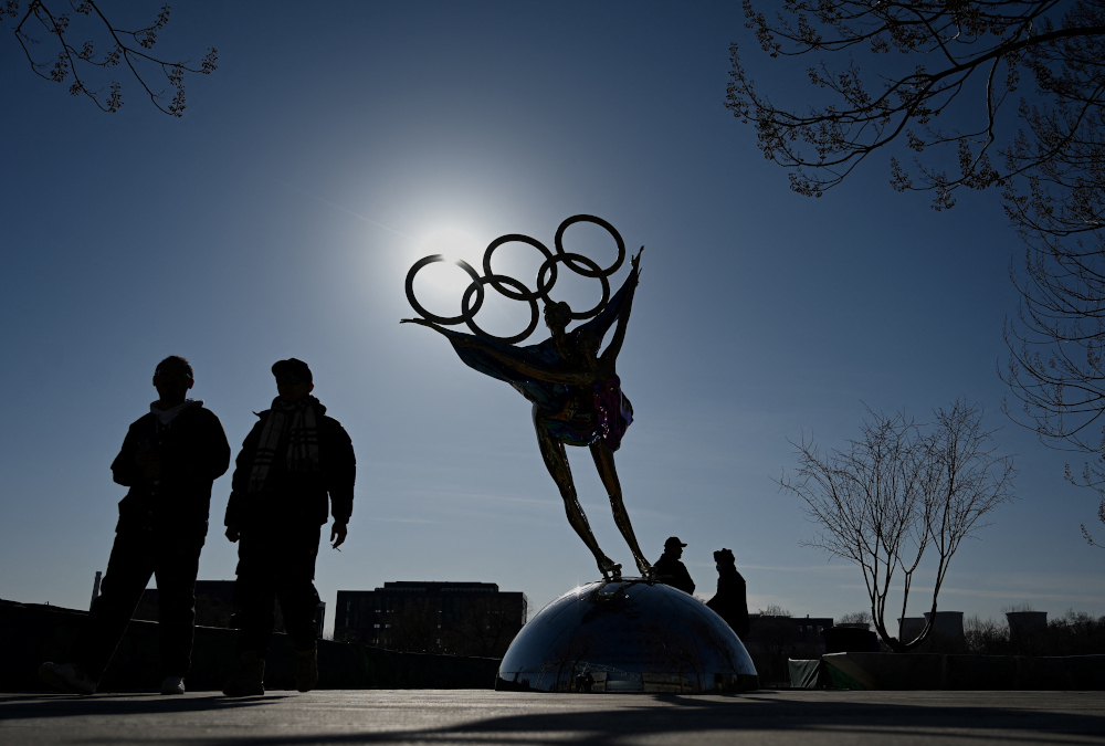 People walk past a statue with the Olympic Rings titled u00e2u20acu02dcDating With the Winter Olympicsu00e2u20acu2122 by Huang Jian, near the headquarters of the Beijing Organising Committee in Shougang Park, Beijing December 7, 2021. u00e2u20acu201d AFP pic 