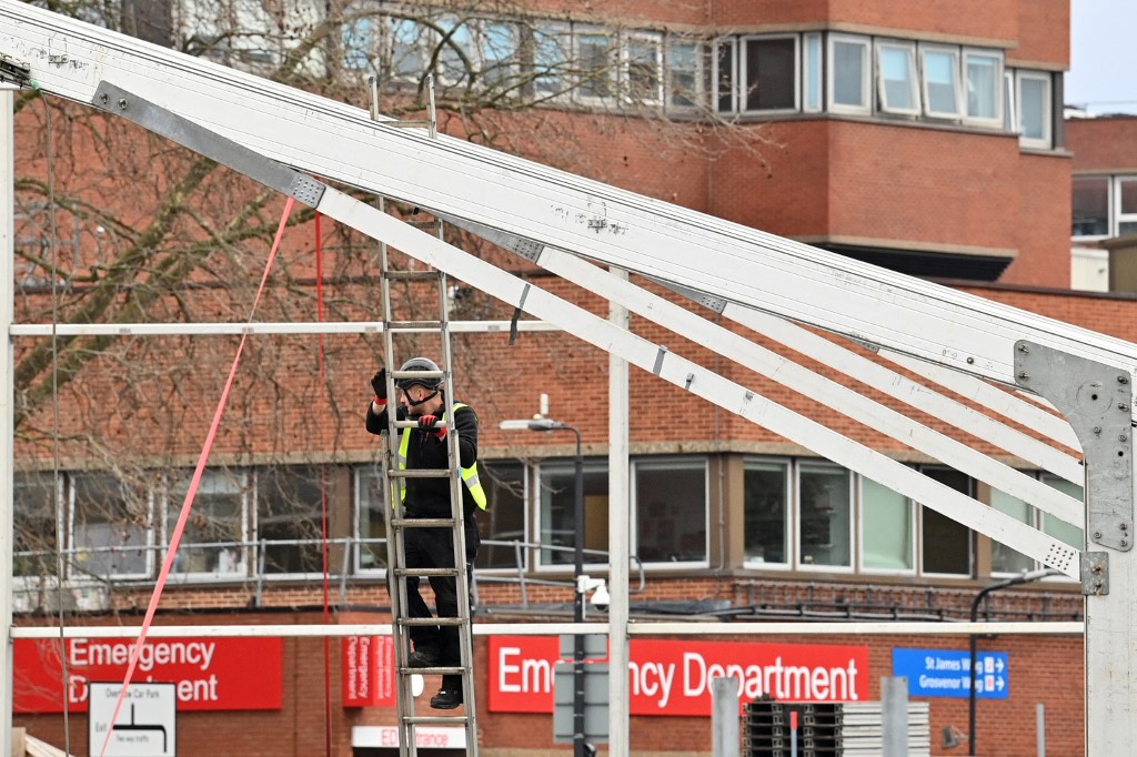 A member of a construction team works on the erection of a temporary field hospital in the grounds of St Georgeu00e2u20acu2122s Hospital in Tooting, south London on December 30, 2021. u00e2u20acu201d AFP pic