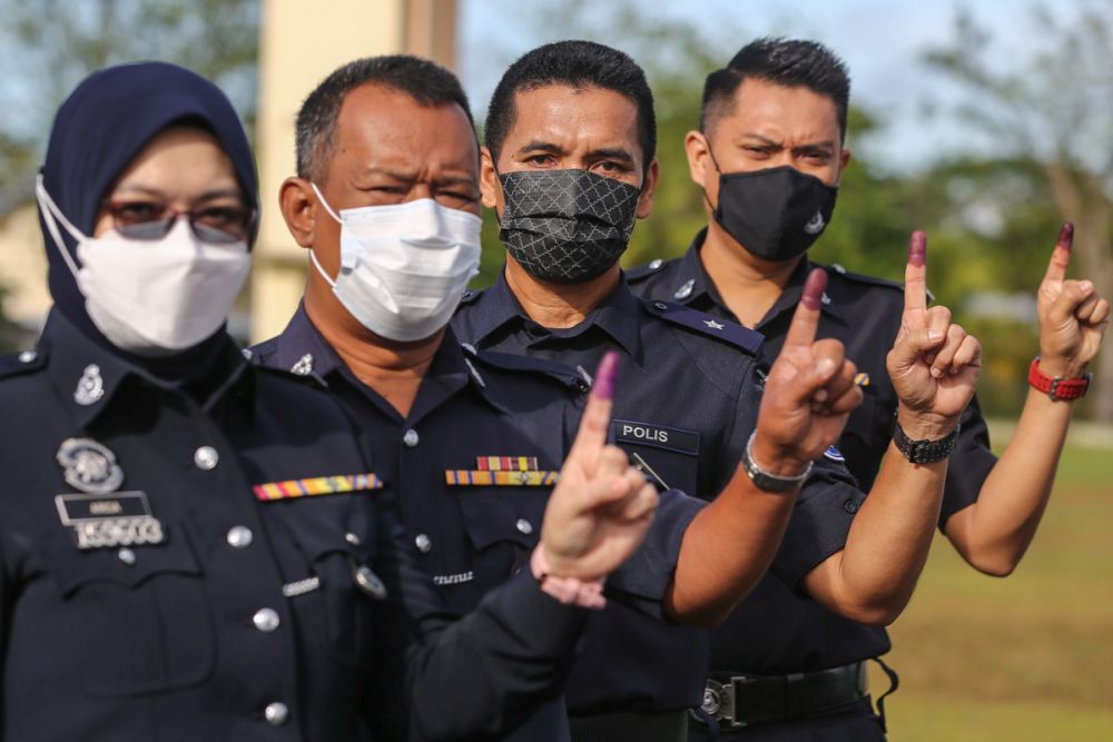 Police officers show their ink-stained fingers after casting their ballots during early voting for the Sarawak state poll in Kuching December 14, 2021. u00e2u20acu201d Picture by Yusof Mat Isa