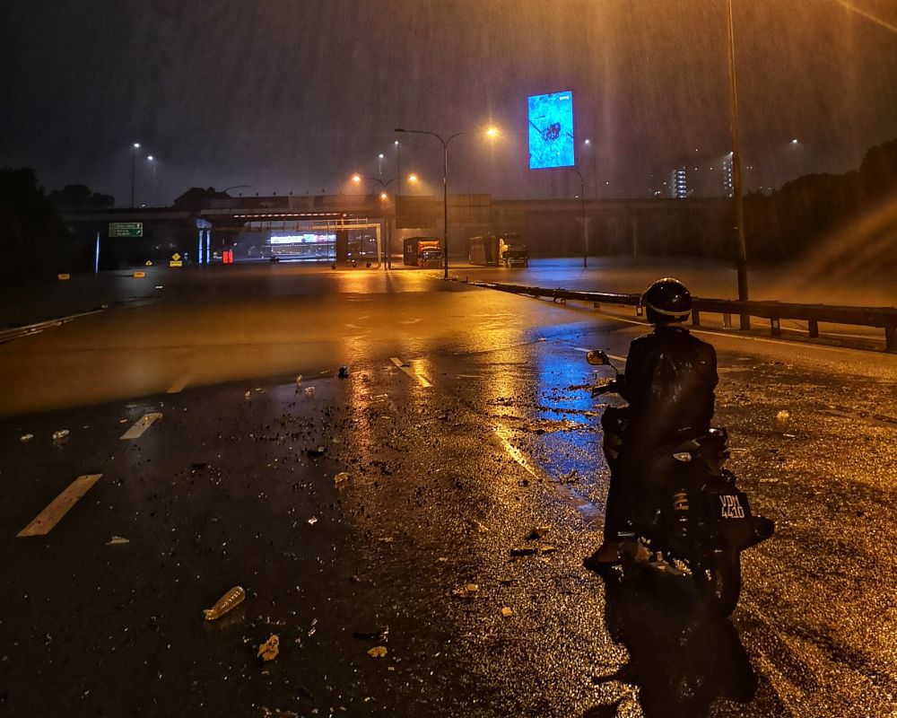A motorcyclist looks on as the Federal Highway is rendered impassable due to floodwaters amid persistent rainfall in the Klang Valley December 18, 2021. u00e2u20acu2022 Picture by Shafwan Zaidonnn