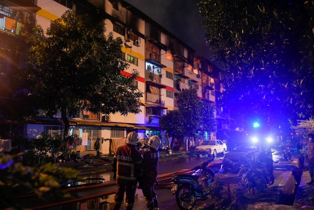 Fire and rescue personnel are pictured at the Sri Johor Flats after a fire broke out there on December 19, 2021. u00e2u20acu201d Picture by Hari Anggara