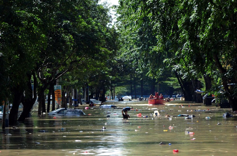 A man is seen wading through chest-high floodwaters in Taman Sri Muda, Shah Alam December 20, 2021.  u00e2u20acu201d Bernama pic