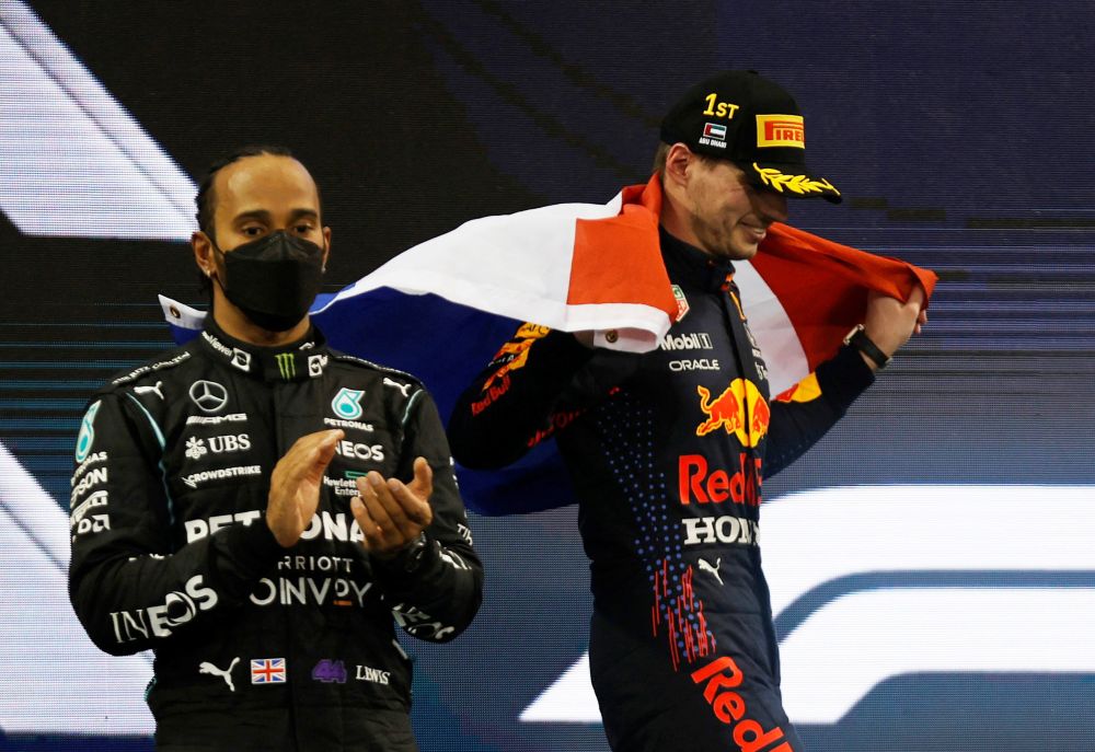 Red Bull's Max Verstappen celebrates winning the Abu Dhabi Grand Prix and the world championship as Mercedes' Lewis Hamilton looks on after finishing second December 12, 2021. u00e2u20acu201d Reuters pic