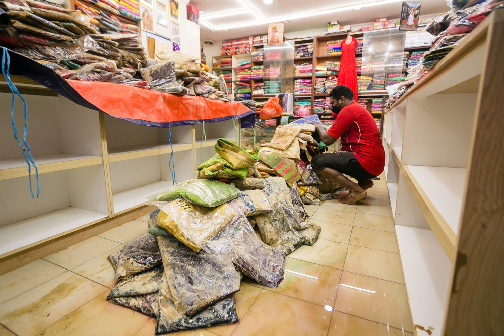 A shop worker cleaning up after the flood at Jalan Hulu Langat, Pekan Batu 11, Cheras, December 20, 2021. u00e2u20acu201d Picture by Devan Manuel