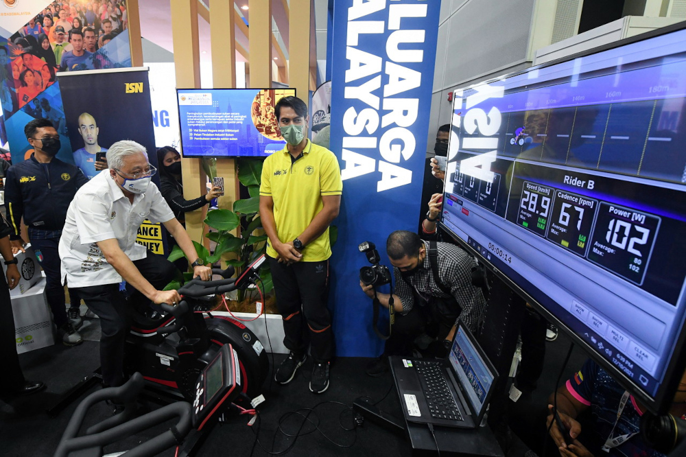 Prime Minister Datuk Seri Ismail Sabri Yaakob rides an electronic bicycle while visiting the Youth and Sports Ministryu00e2u20acu2122s exhibit at the 100-Day KeluargaMalaysia Aspiration Programme, Kuala Lumpur Convention Centre, December 10, 2021. u00e2u20acu201d Bernama pic 