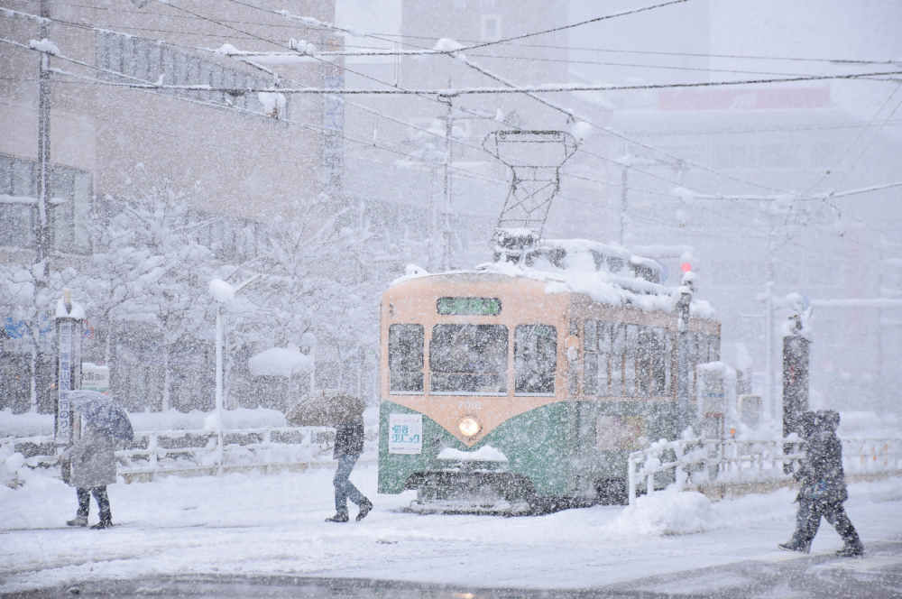 People cross a street in heavy snow in the city of Toyama, Toyama prefecture, brought by an extreme cold front along western and northern parts of the country, December 27, 2021. u00e2u20acu201d STR/Jiji Press handout pic via AFPnn