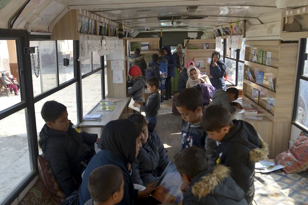 Children stand inside a mobile library which opened its doors for the first time since the Taliban's return to power, in Kabul on December 5, 2021. u00e2u20acu201d AFP picnn