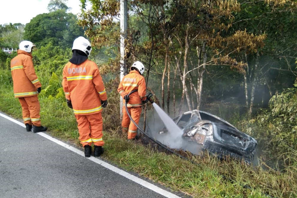 A Bomba photo showing firefighters putting out the remaining fire on the car. u00e2u20acu201d Borneo Post pic