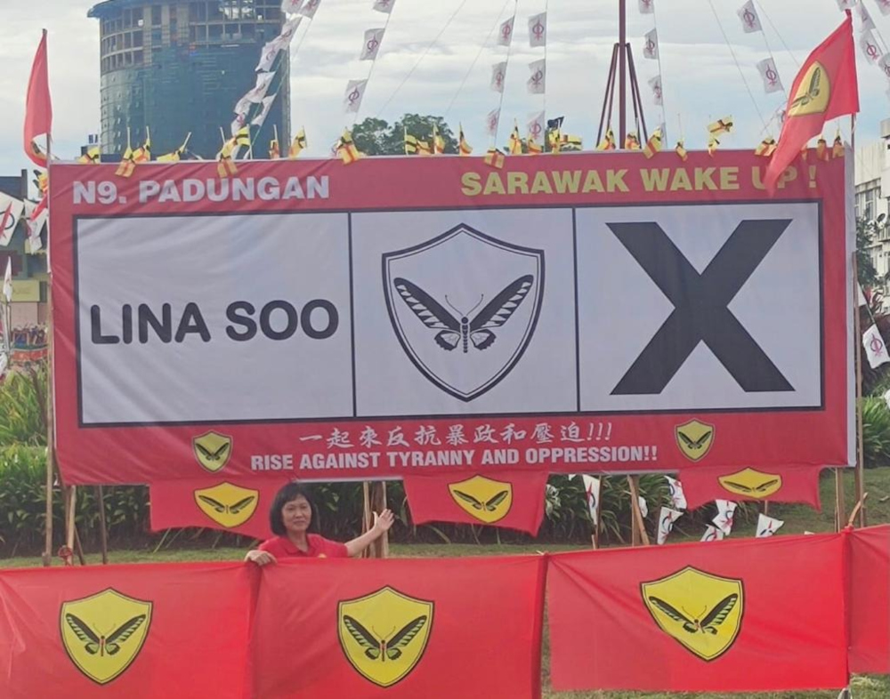 Aspirasi candidate for Padungan Lina Soo pointing to the revamped poster. u00e2u20acu201d Borneo Post Online pc