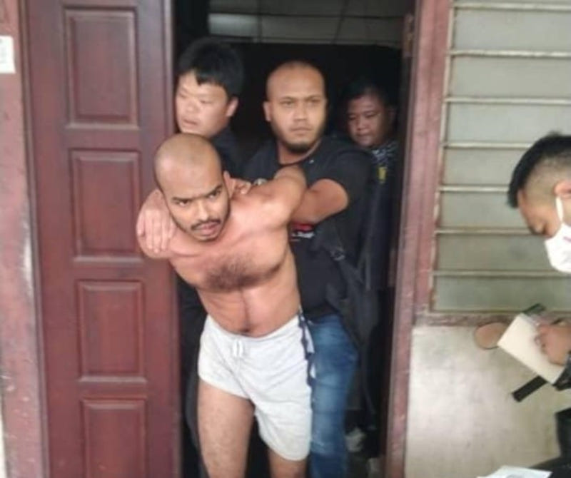 The 32-year-old wanted man known as u00e2u20acu02dcLong Tigeru00e2u20acu2122 is escorted from a house in Sungai Petani, Kedah, December 28, 2021, following his arrest. u00e2u20acu201d Picture from Facebook